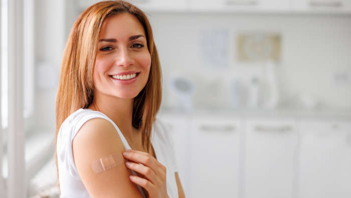 Pflaster am Oberarm einer Frau, nach FSME Impfung